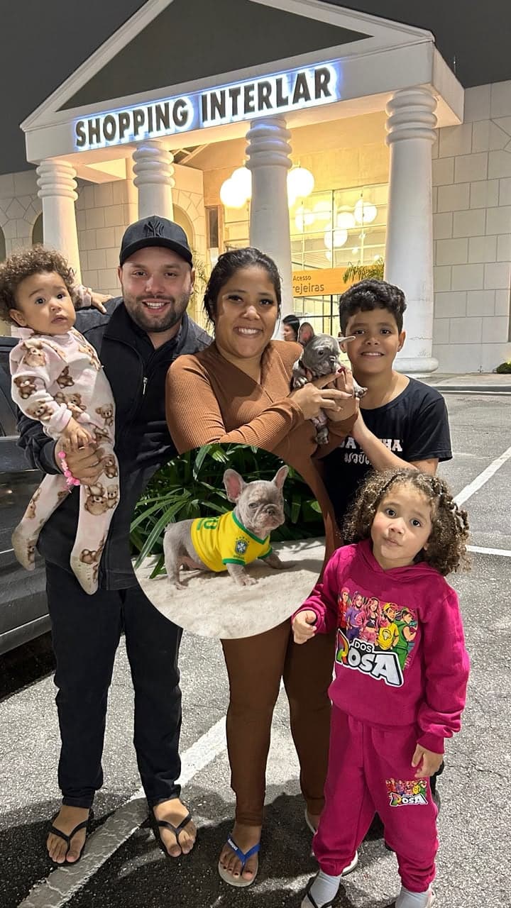 Família com três crianças recebendo um filhote de Bulldog Francês