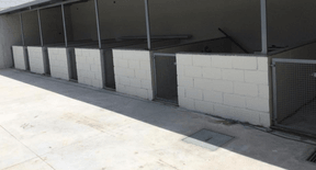 Fileira de baias externas cobertas, ao lado do pátio